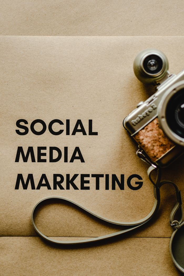 services-01 Close-up of a vintage camera next to a social media marketing concept text on a brown background.