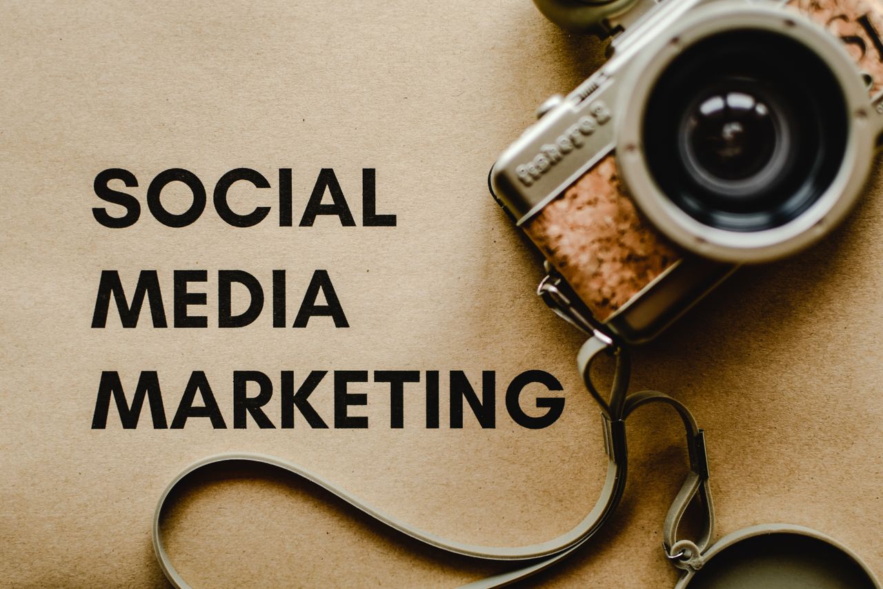 services-02 A vintage camera on brown paper with 'SOCIAL MEDIA MARKETING' text, perfect for marketing visuals.